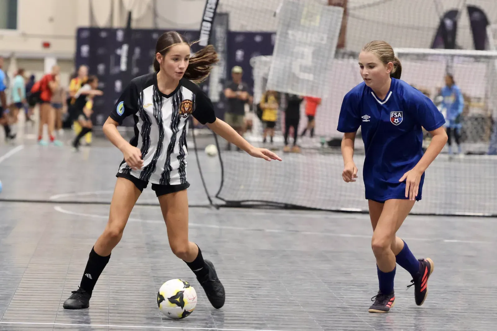 A Lions player in the striped kit taking on a defender